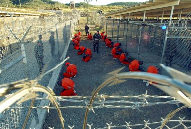 A file photo shows detainees sitting in a holding area watched by military police at Camp X-Ray inside Naval Base Guantanamo Bay