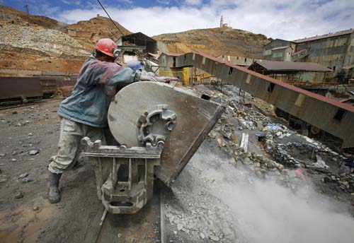 A Bolivian miner empties a rail car outside the Pailaviri mine in the Cerro Rico mountain in Potosi