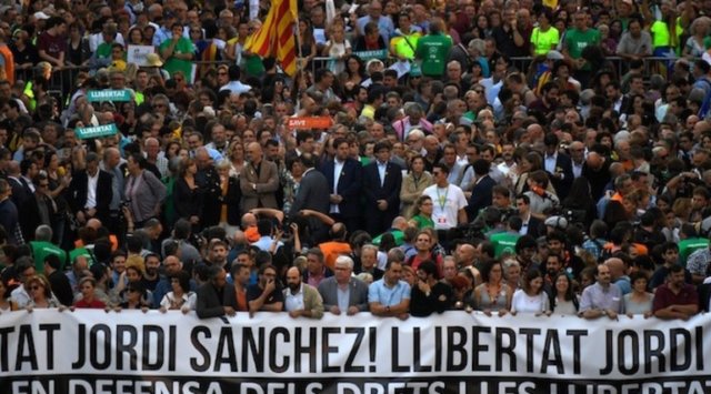 ?Catalan regional president Carles Puigdemon (C) and Catalan regional vice-president and chief of Economy and Finance Oriol Junqueras (L) attend a demonstration on October 21, 2017 in Barcelona, to support two leaders of Catalan separatist groups, Jordi Sanchez and Jordi Cuixart, who have been detained pending an investigation into sedition charges. Spain announced that it will move to dismiss Catalonia's separatist government and call fresh elections in the semi-autonomous region in a bid to stop its leaders from declaring independence. / AFP PHOTO / LLUIS GENE